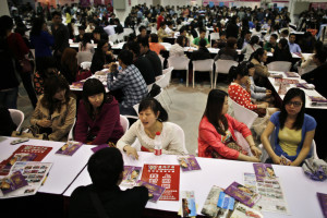 Women sit and talk as they wait to meet men during a matchmaking event in Shanghai